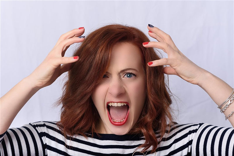 A woman with her hands on her head, expressing frustration