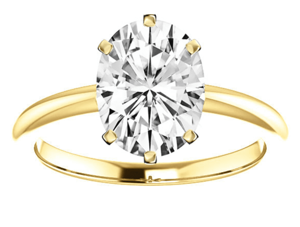 An oval shaped diamond set in 6 prongs in a yellow gold engagement ring 