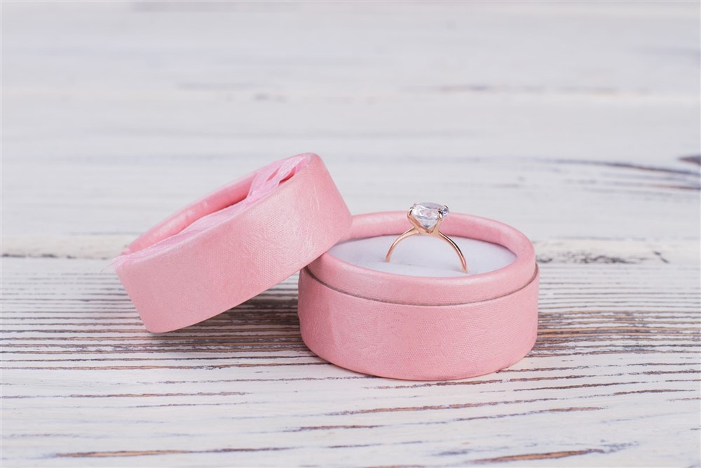 A diamond ring in a pink ring box with the lid off 