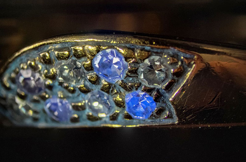 Old single cut diamonds in a ring displaying different degrees of fluorescence 