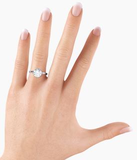 A two carat diamond ring on a woman's ring finger