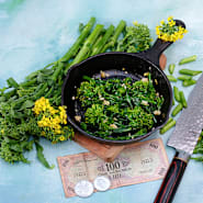 Cooked Natalina Di Fasano Cima Grande Broccoli Rabe in a cast iron skillet surrounded with fresh rabe.