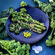 Natalina Di Fasano Cima Grande Broccoli Rabe sauteed on a plate with fresh rabe around the plate. 