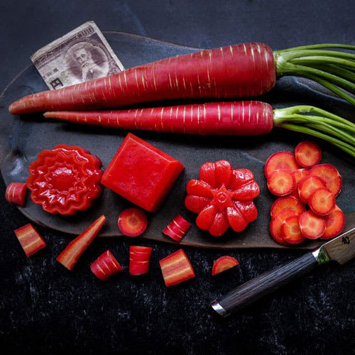 Heirloom fall carrots just pulled from the soil, featuring Kyoto Red, New Kuroda, and Oxheart varieties.