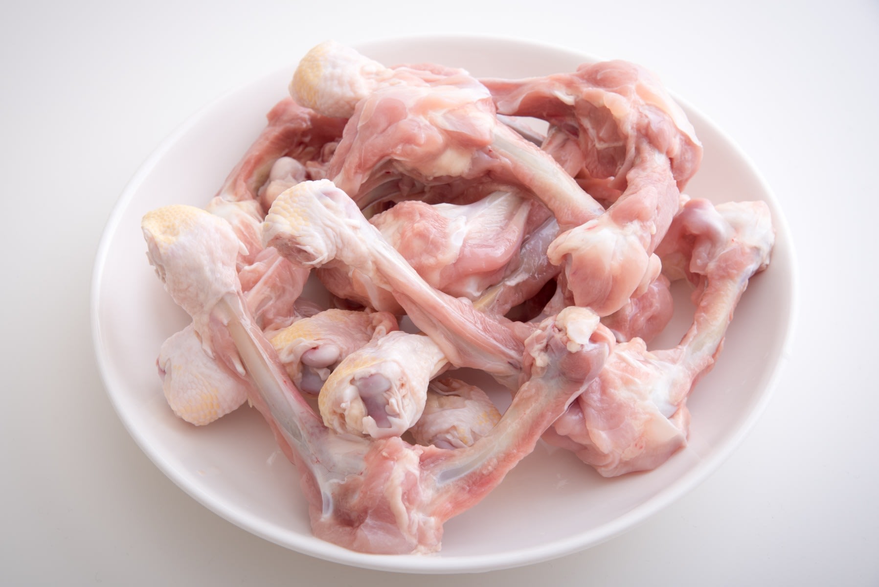AdobeStock photo of raw chicken parts on a white plate
