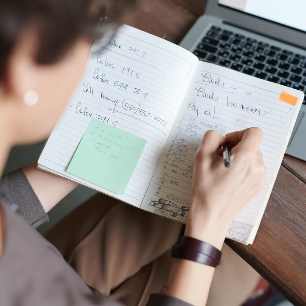 woman writing on a notebook