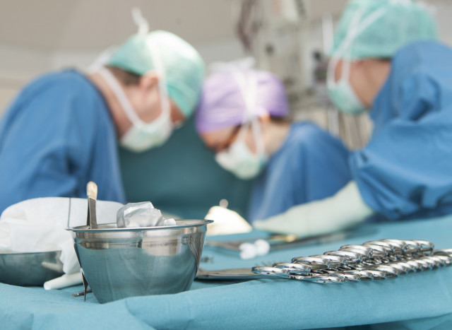 Operationsinstrument och vårdpersonal i operationskläder.