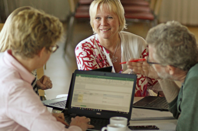 Utvecklingsledare runt dator.