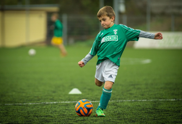 Pojke sparkar fotboll.