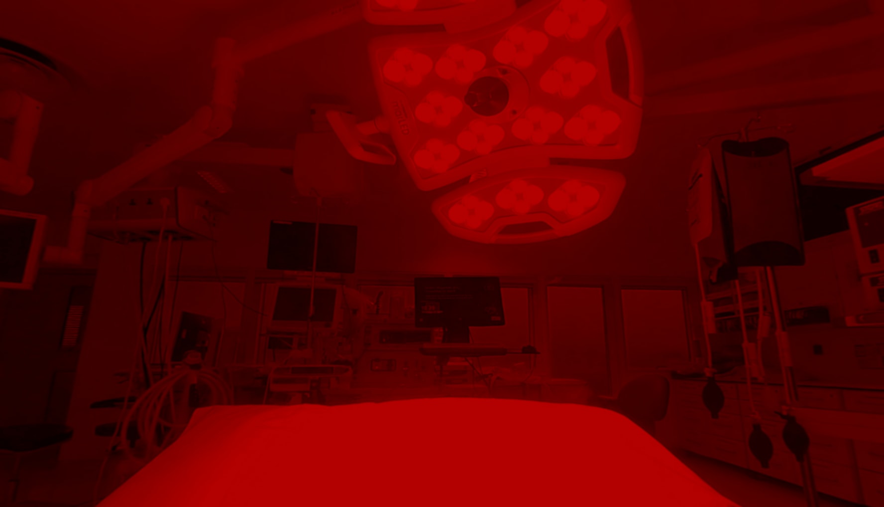 A blood red filtered photograph of an operating surgery theatre from the inside view of a VR headset.