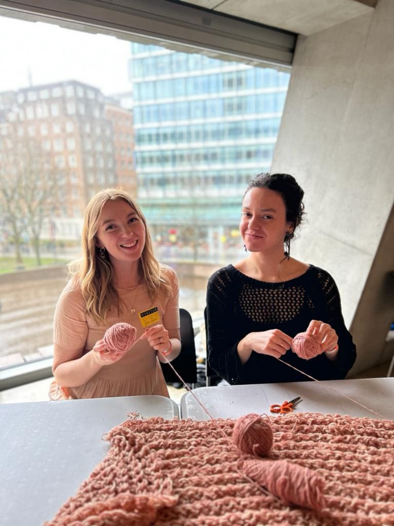 Two women sat down, winding yarn