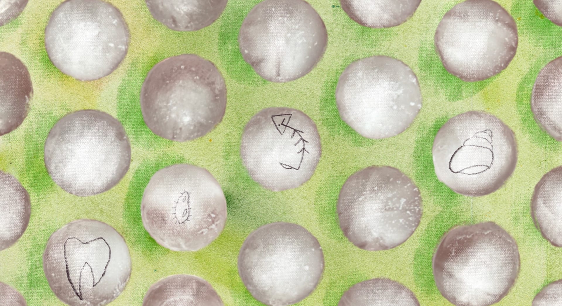 Round ice cubes on green background.