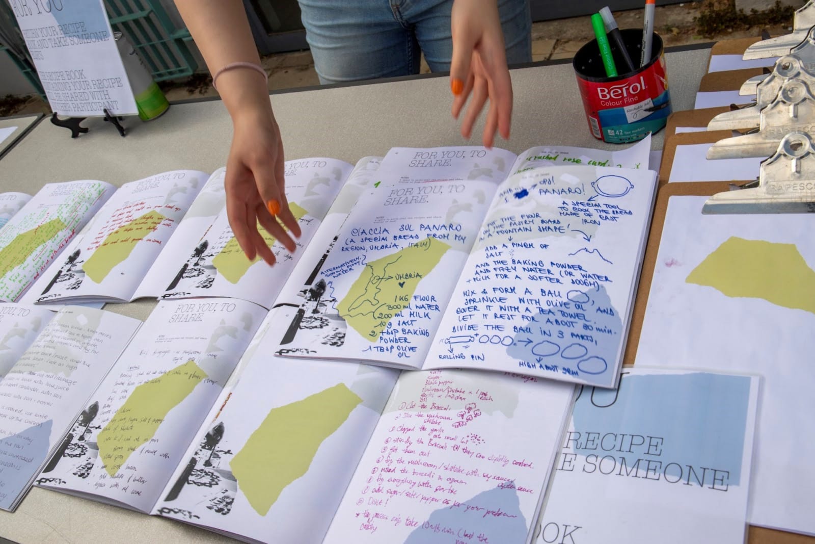 Various recipe books with family recipes written and shared by the public are laid on the table. 