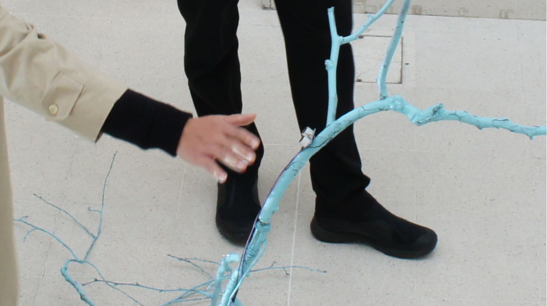 Visitor's outstretched hand interacting with the sculpture.