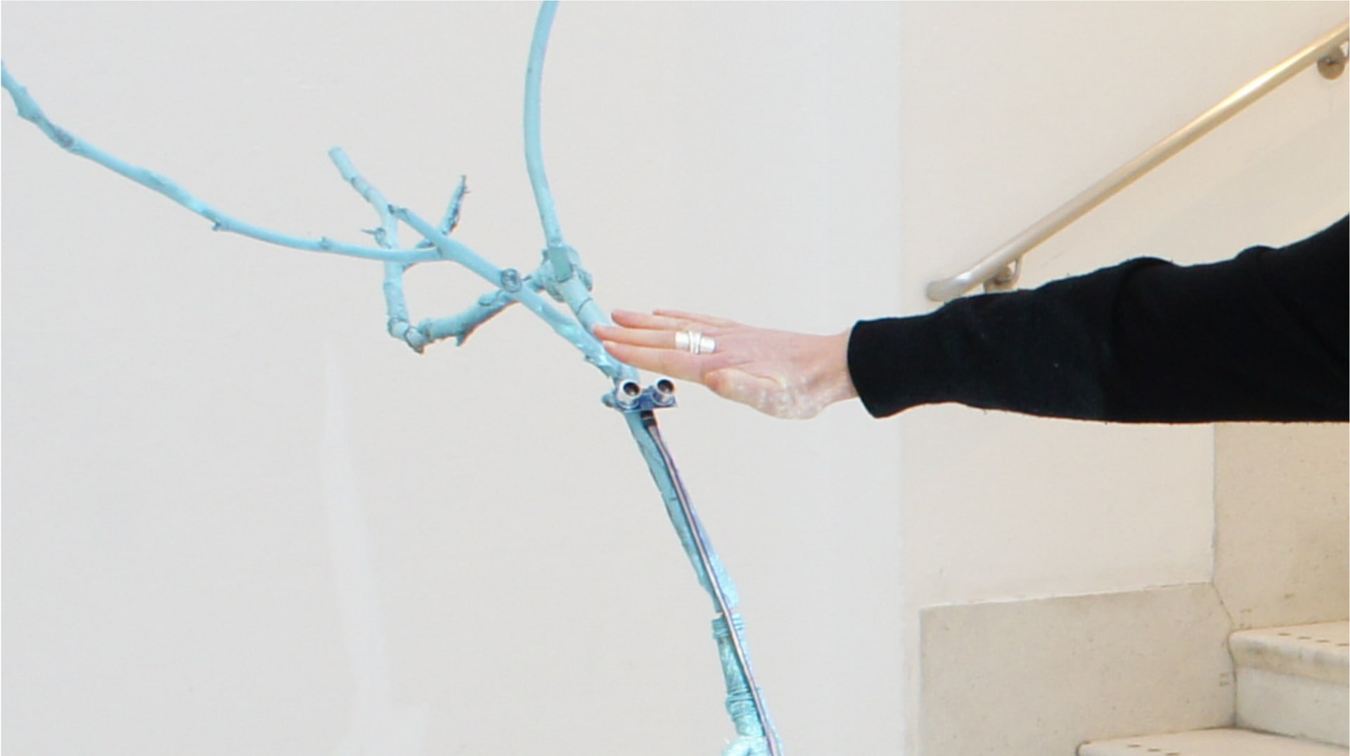 Visitor's hand interacting with the sculpture. 