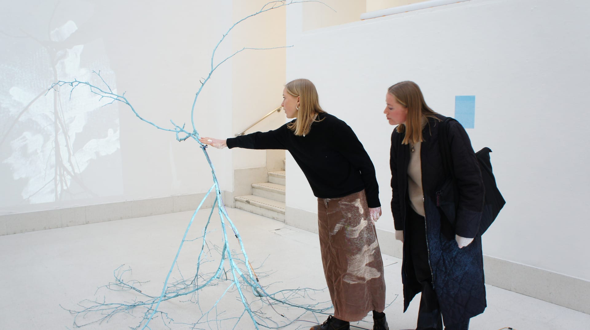 Two visitors interacting with the sculpture. 