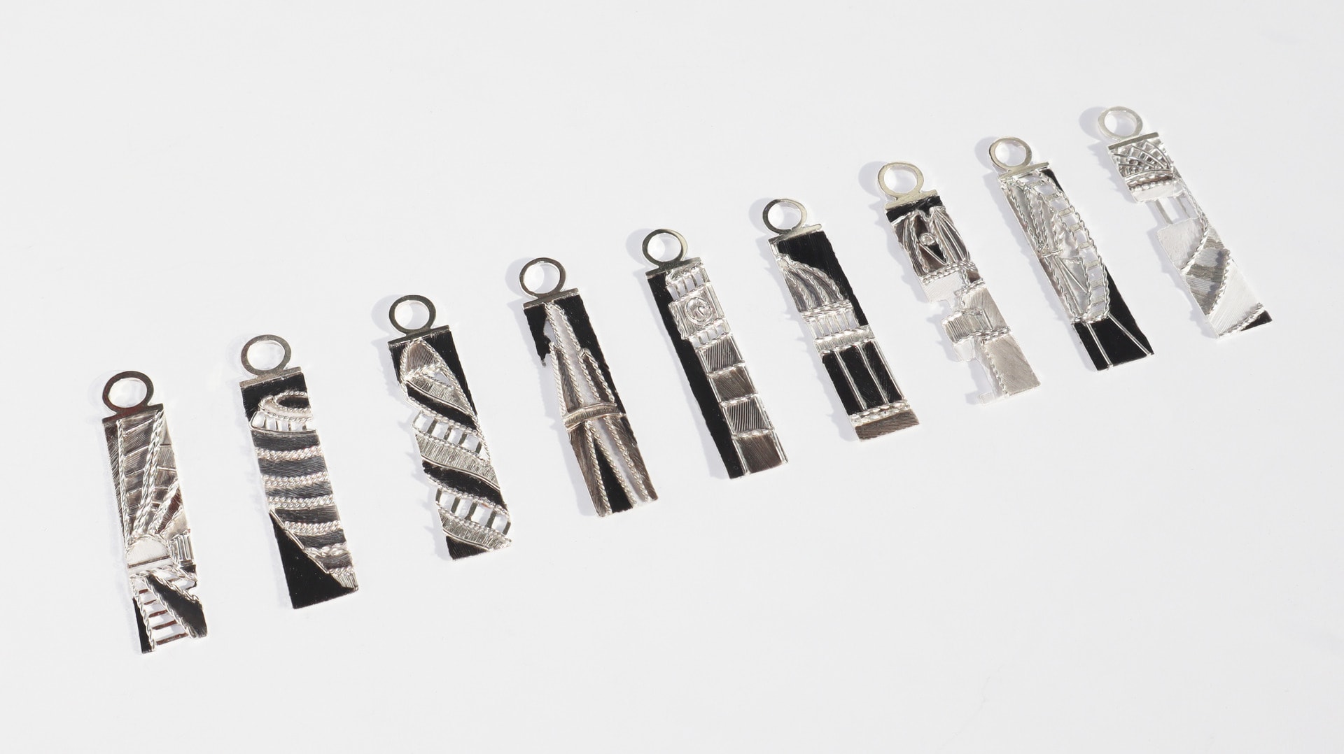 A set of nine kingfisher craft pendants made of silver and pigeon feathers