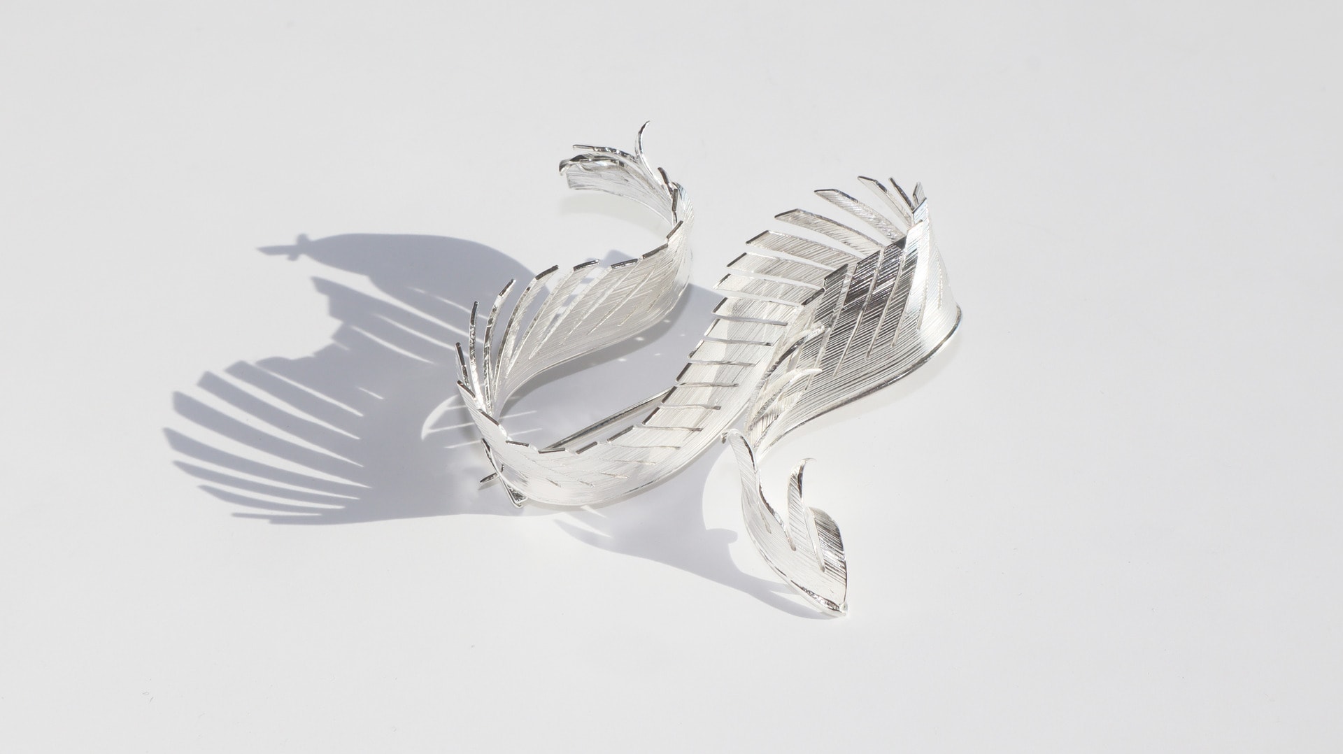 Photo of a silver brooch inspired by feathers