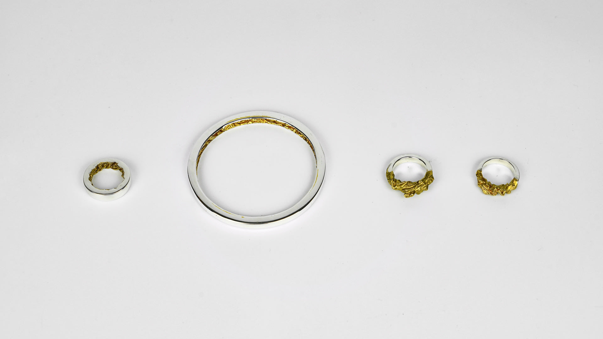 Half of the piece is a basic polished ring and bangle, the other half is gilded section carved in the form of a water wave.