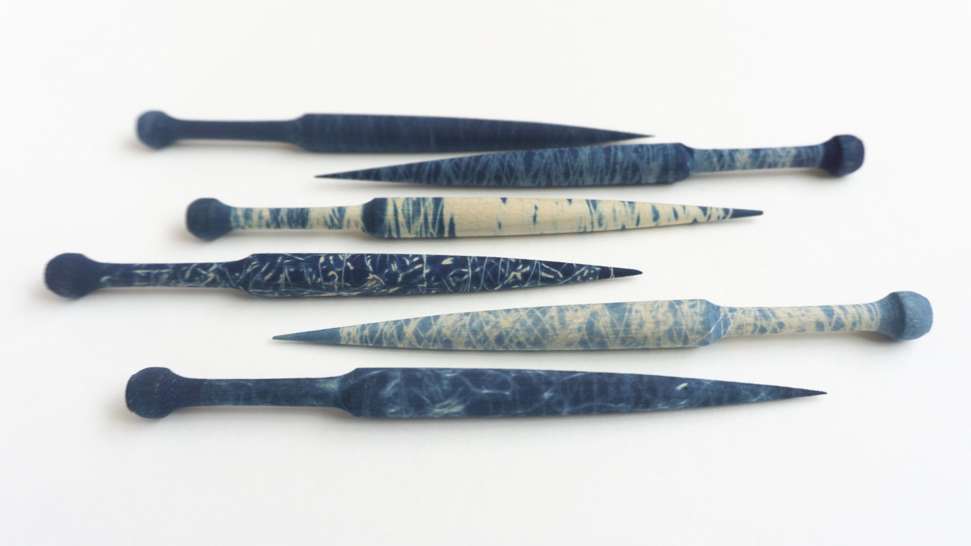 Bobbins warped to resist indigo dye in sections. 