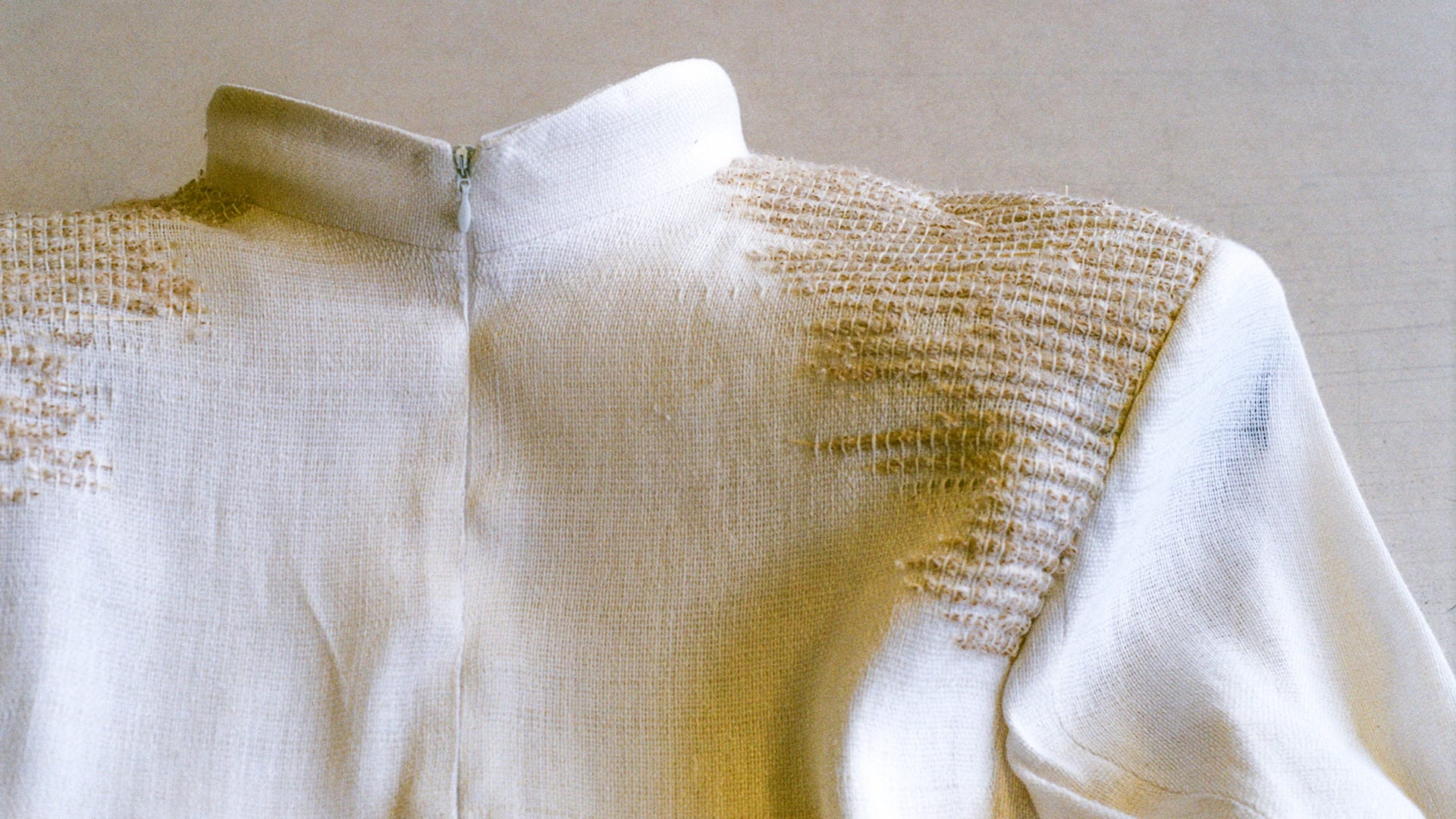 detail image of a bespoke cream coloured jacket showing the pampas grass weave detail on the shoulder