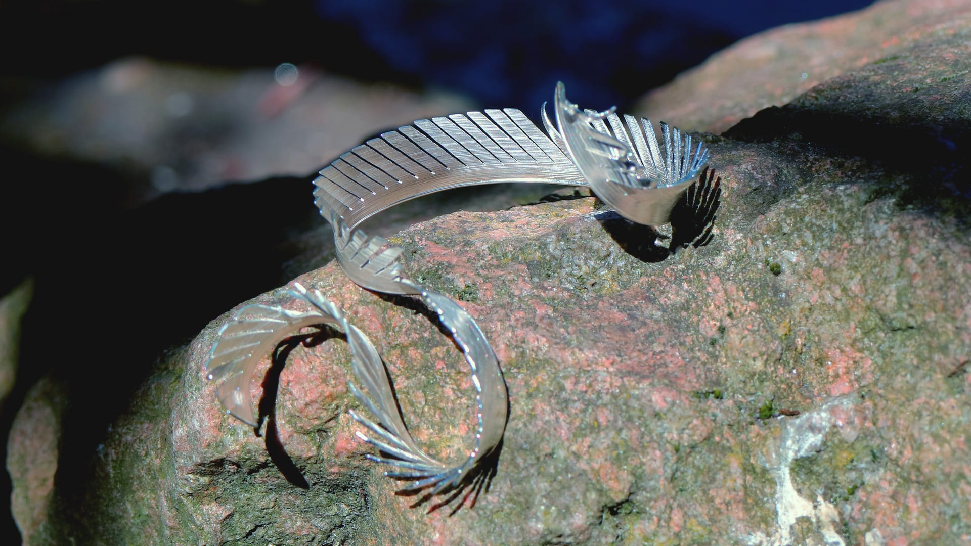 This is a collection of nine kingfisher craft pendants made of silver and pigeon feathers, showcasing nine London landmarks