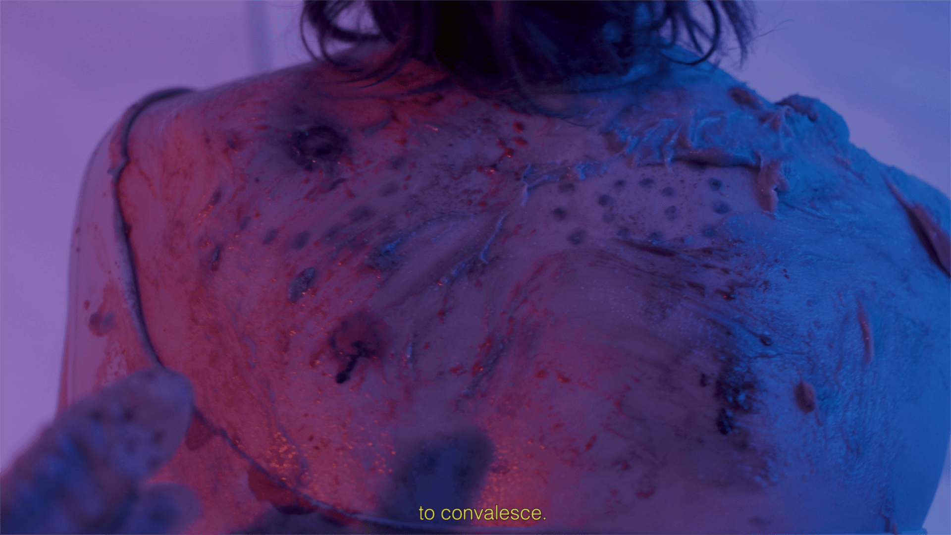 Still from Artist's film entitled True Medicine. Colourful ointments are applied to fake wounds.