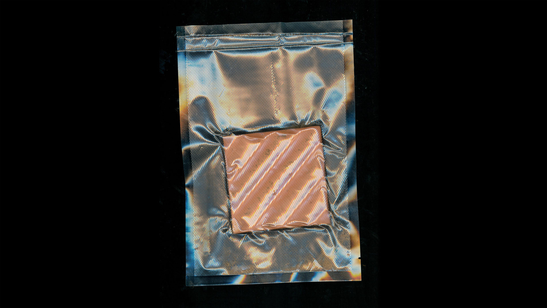 a vacuum sealed transparent bag featuring a contaminated ceramic azulejo tile. Black background