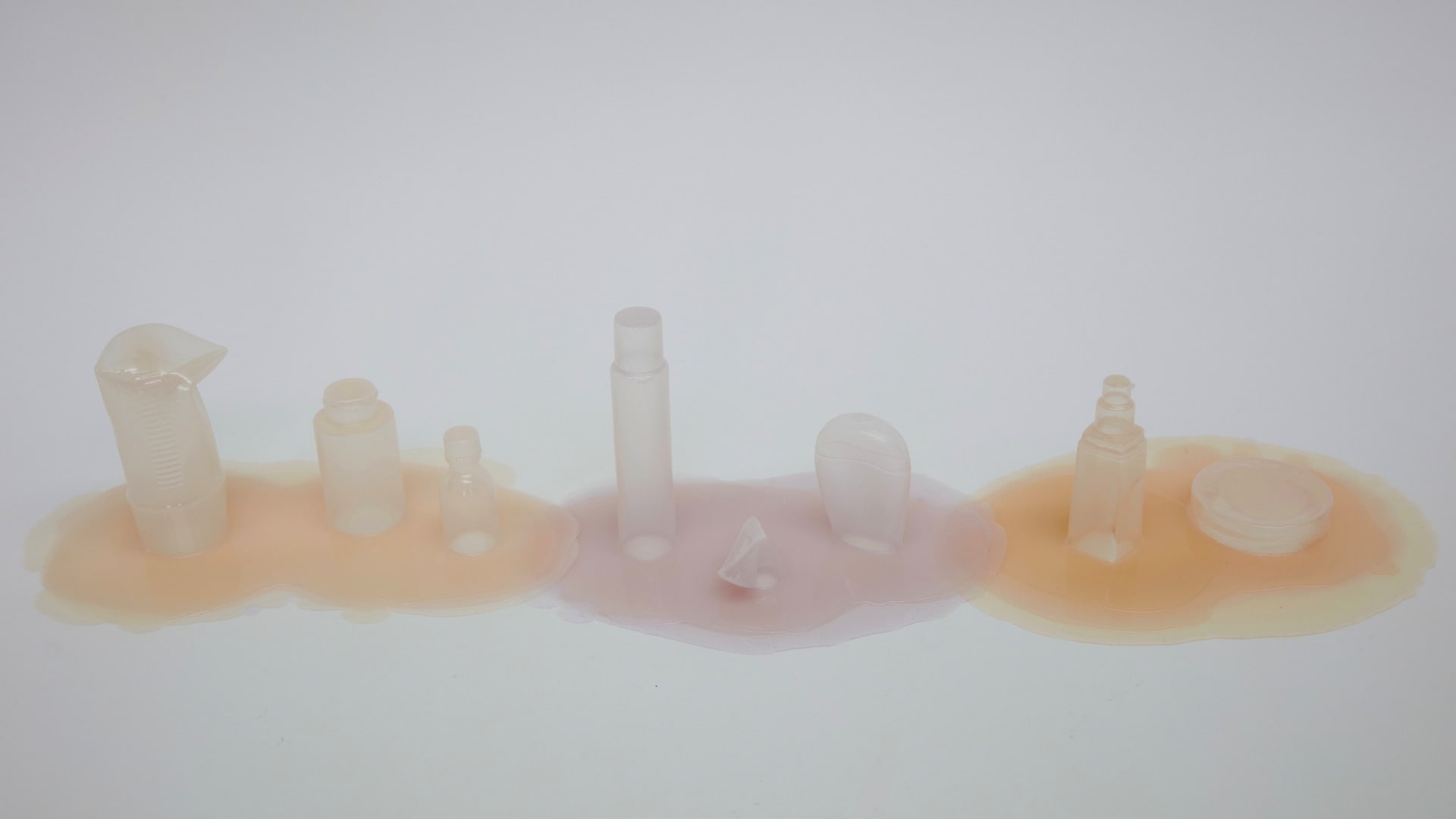 Row of 3 groups of 2-4 bottles in nude, orange, and light purple. 