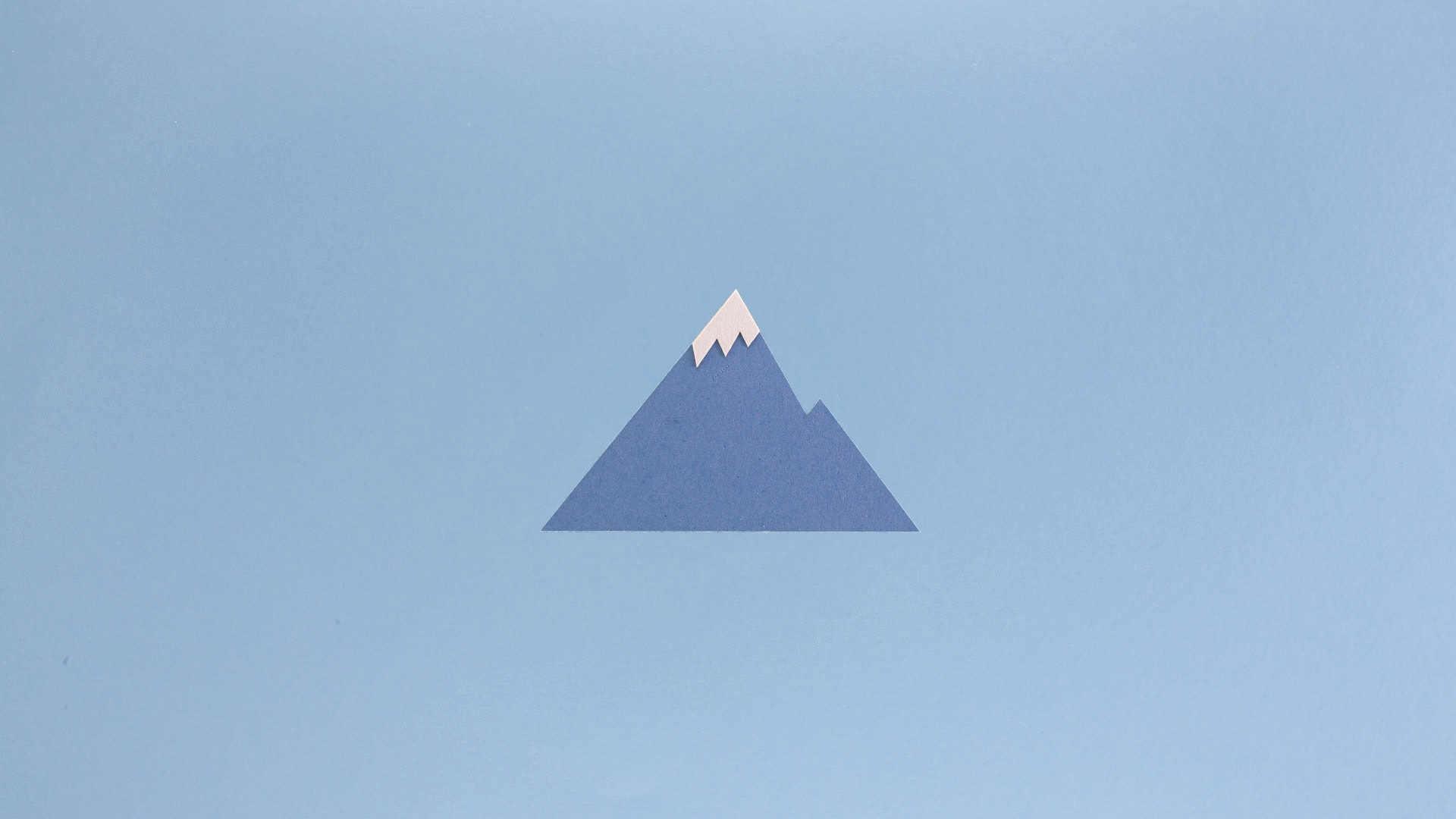 Blue paper mountain on light blue backgroun