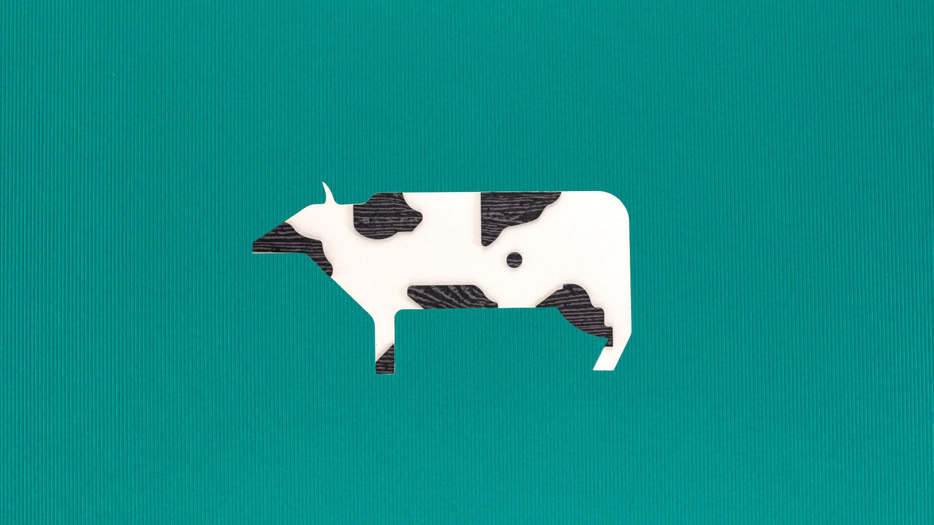 Paper cow on green background