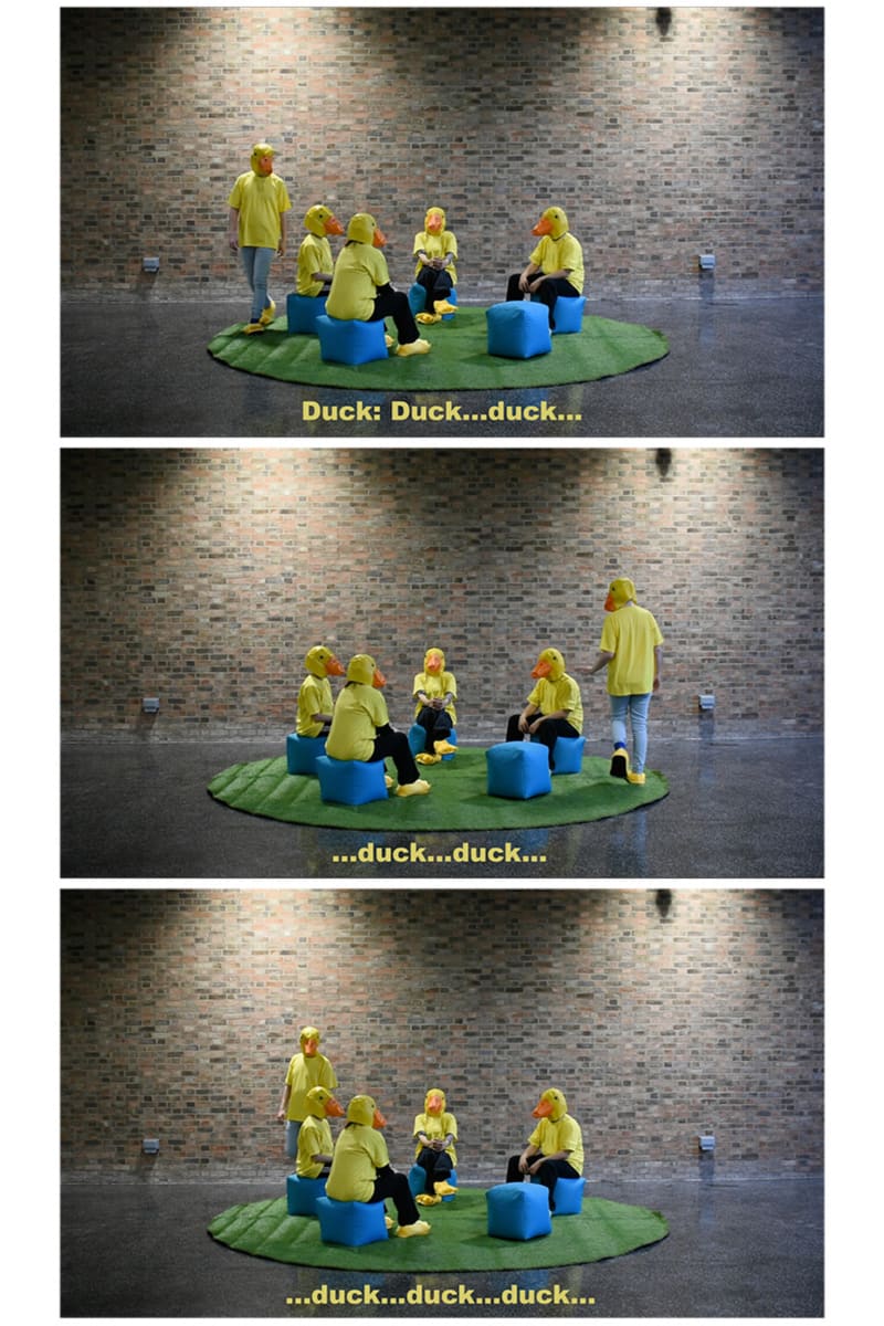 Performance, 4 people dressed as ducks sat on beanbags.