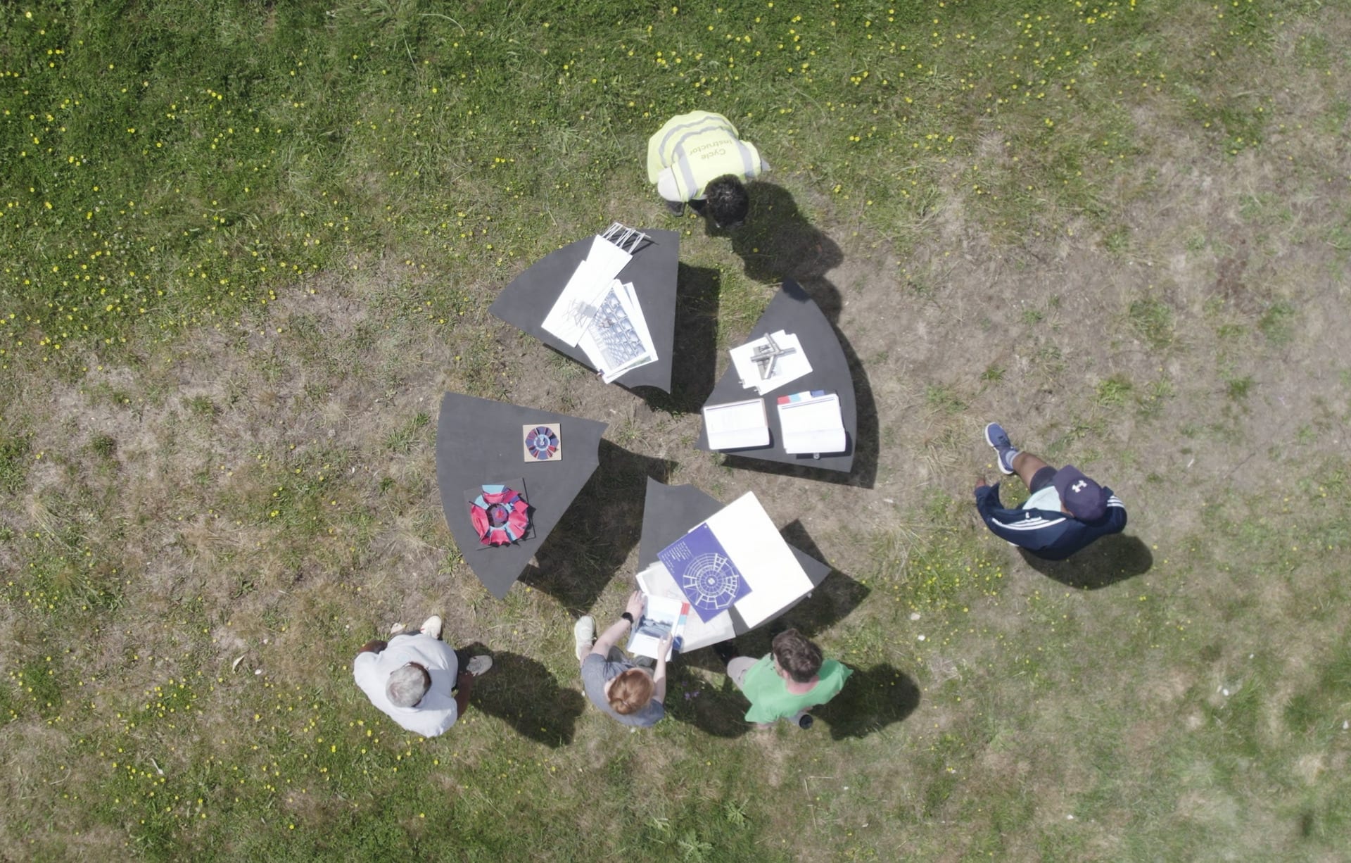Drone shoot from above of circular collective table and disabled cyclists engaging around it