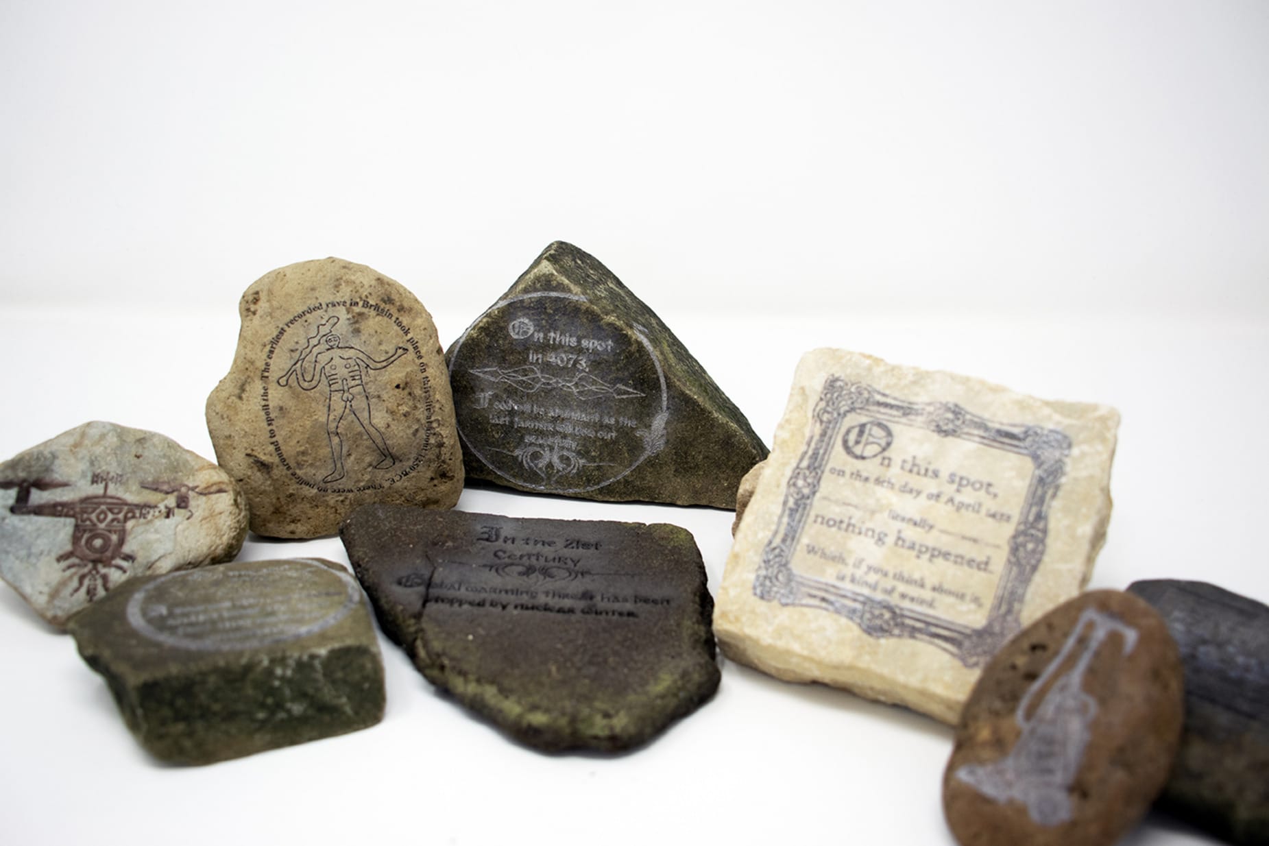 A group of stone with absurd phrases and images laser engraved on them.