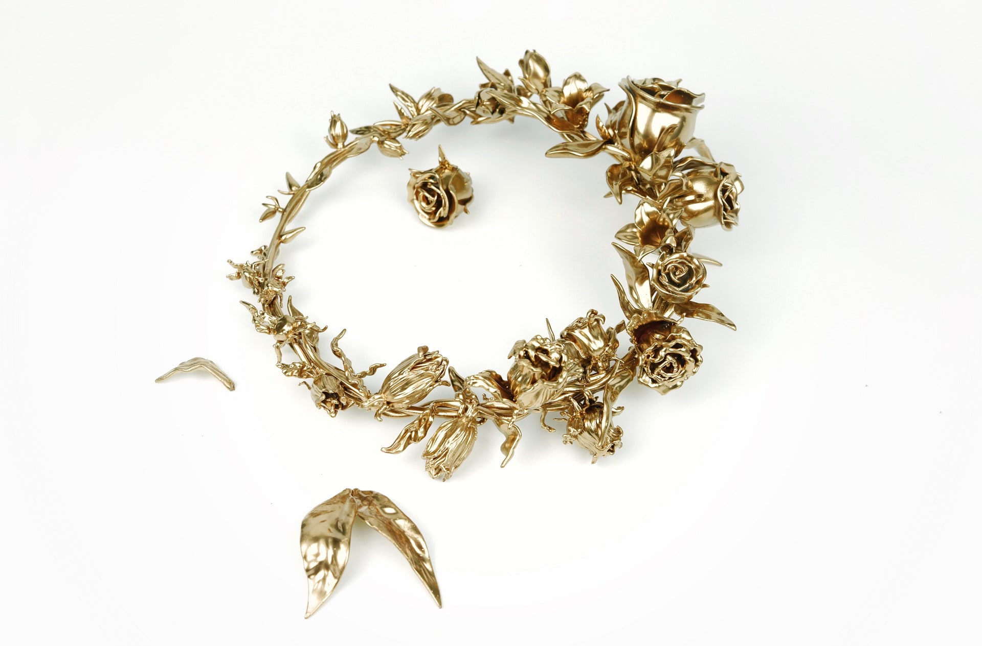 A cyclical wreath made of brass embodying the cycle of bloom to decay.