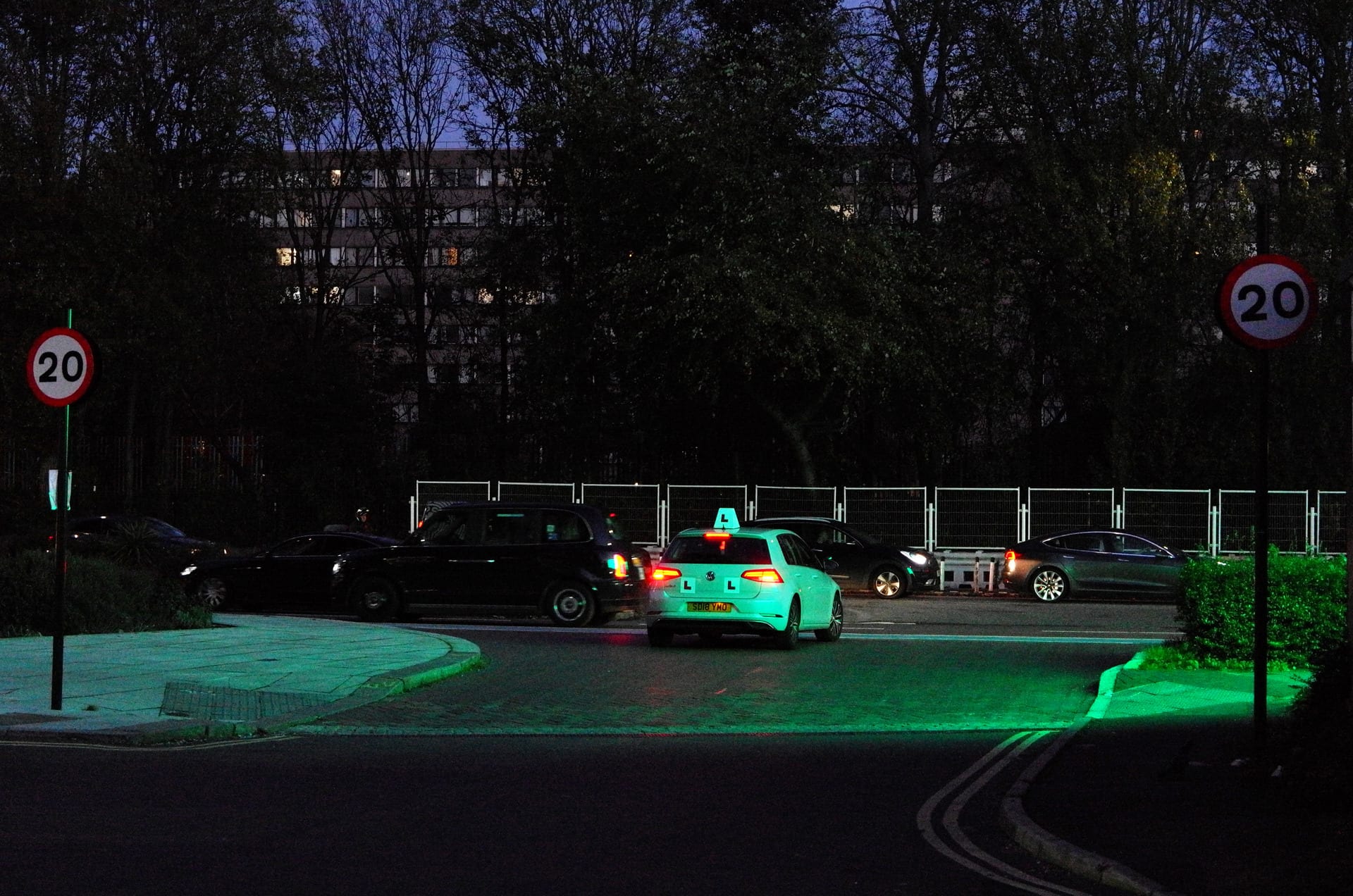 Cab at a street entrance at night, billboards glowing green