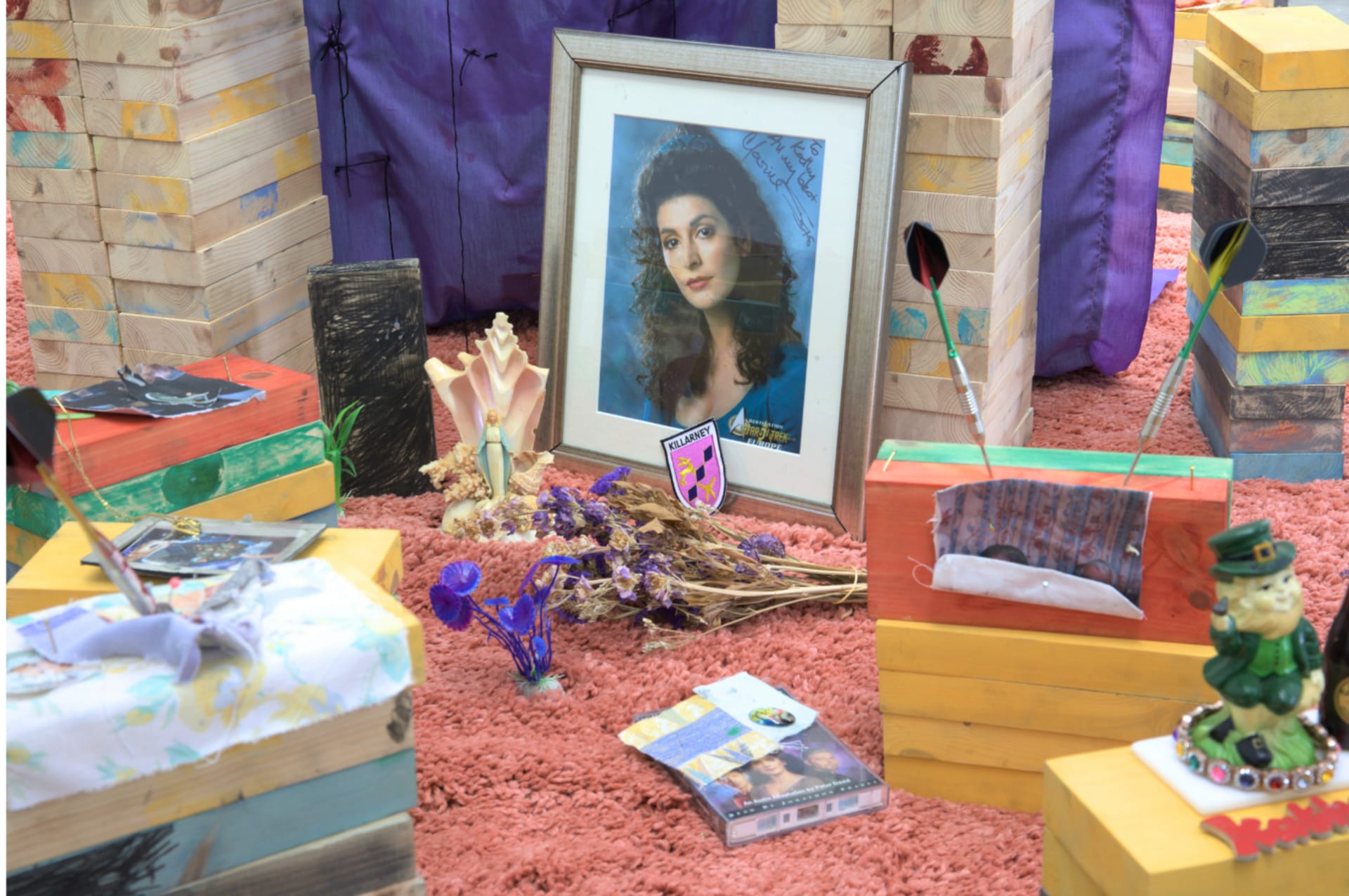 A collection of objects including star trek fandom, religious objects and plastic statues on a rug 