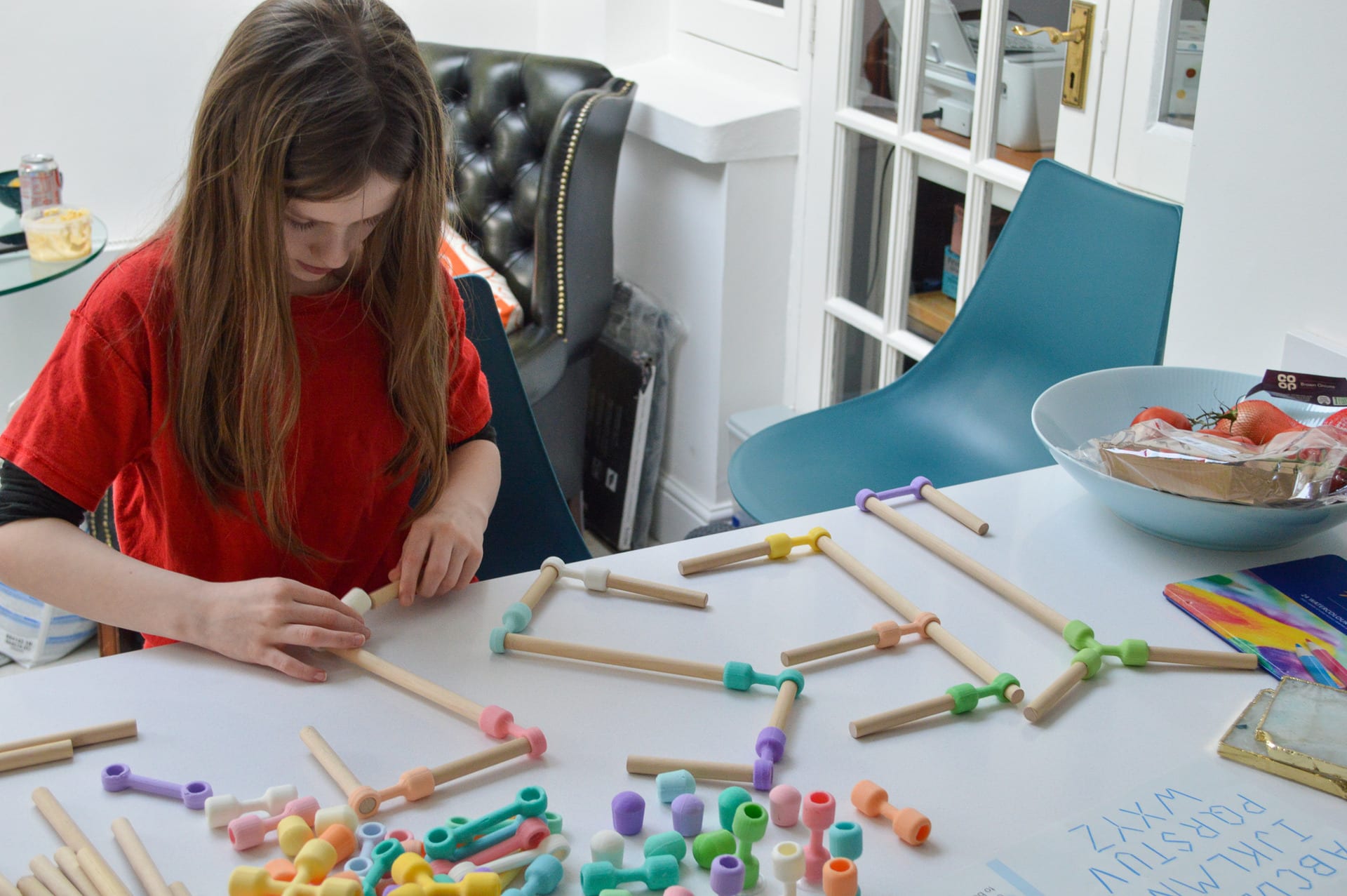 A girl spells her name out of the parts.