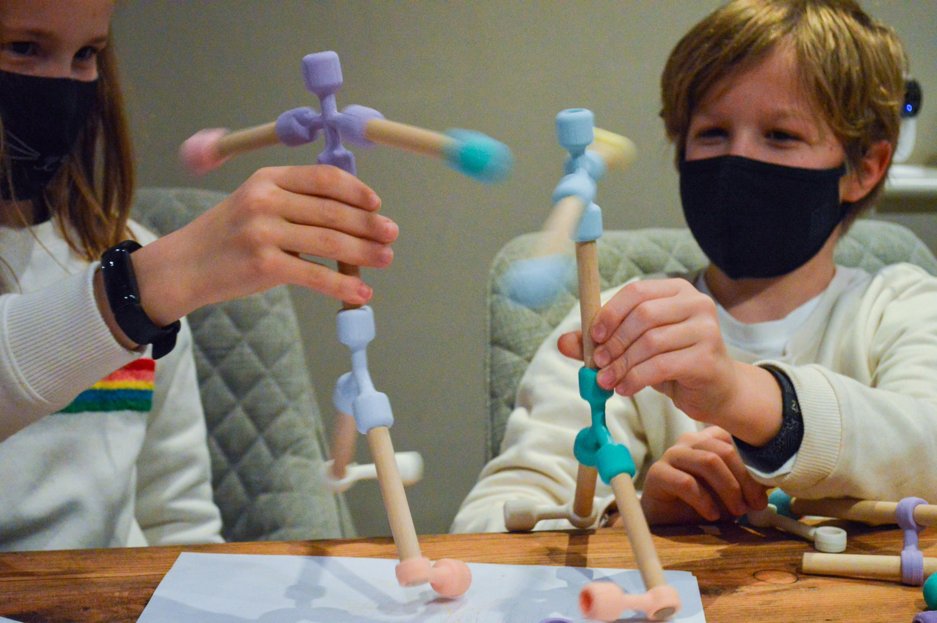 A girl and a boy playing with Wiggel stick people.