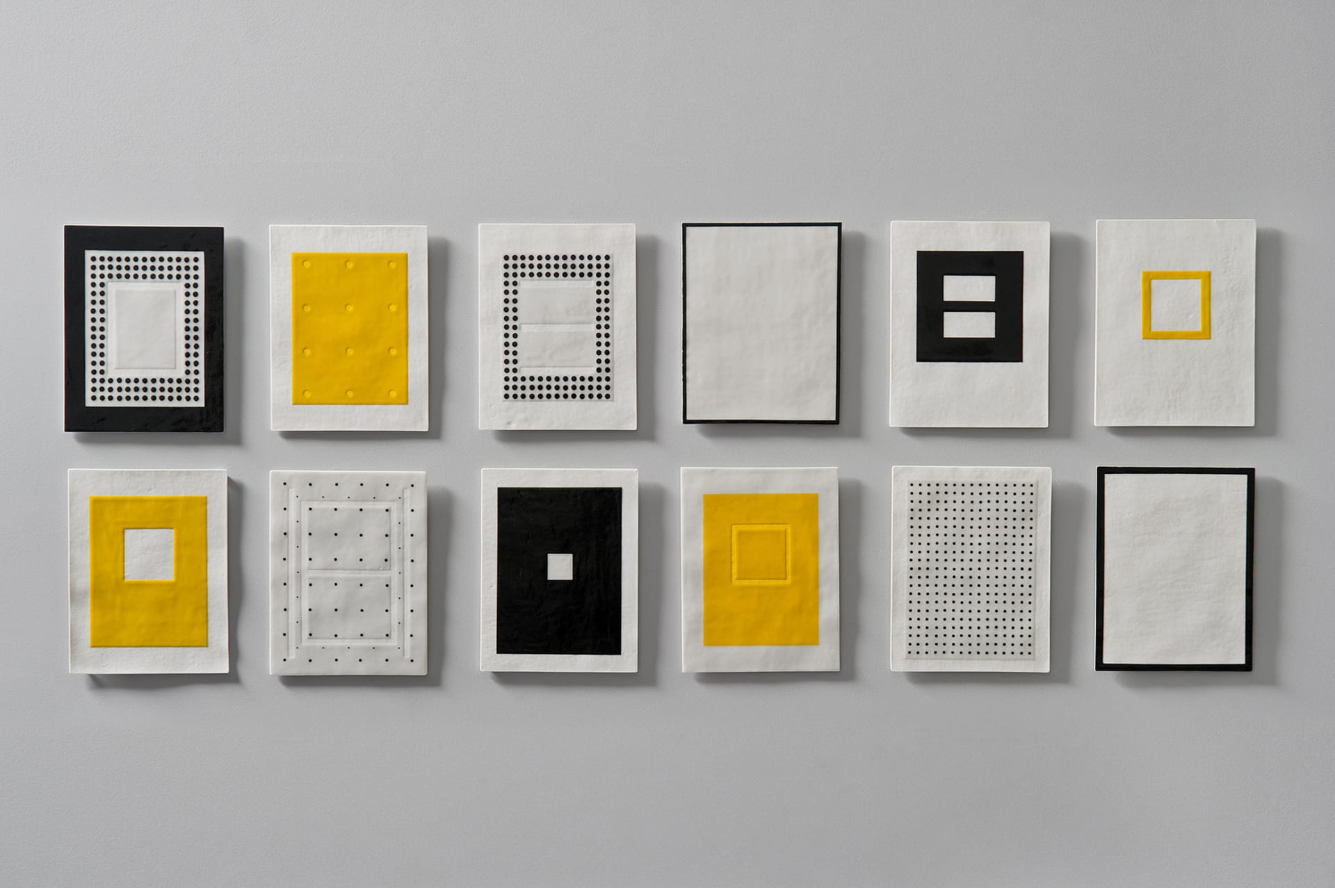 Twelve Porcelain Pages wall mounted with yellow and black slip 