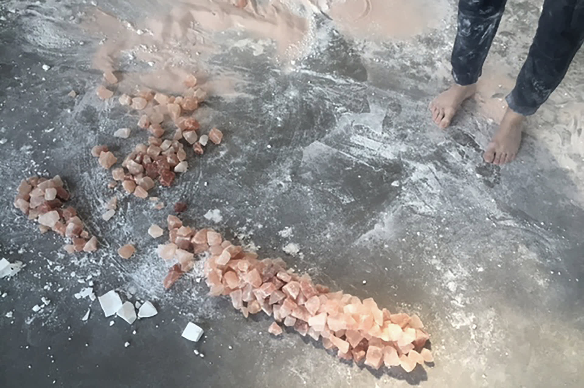 Himalayan salt rocks and chalk on a grey floor. Performance remainders.