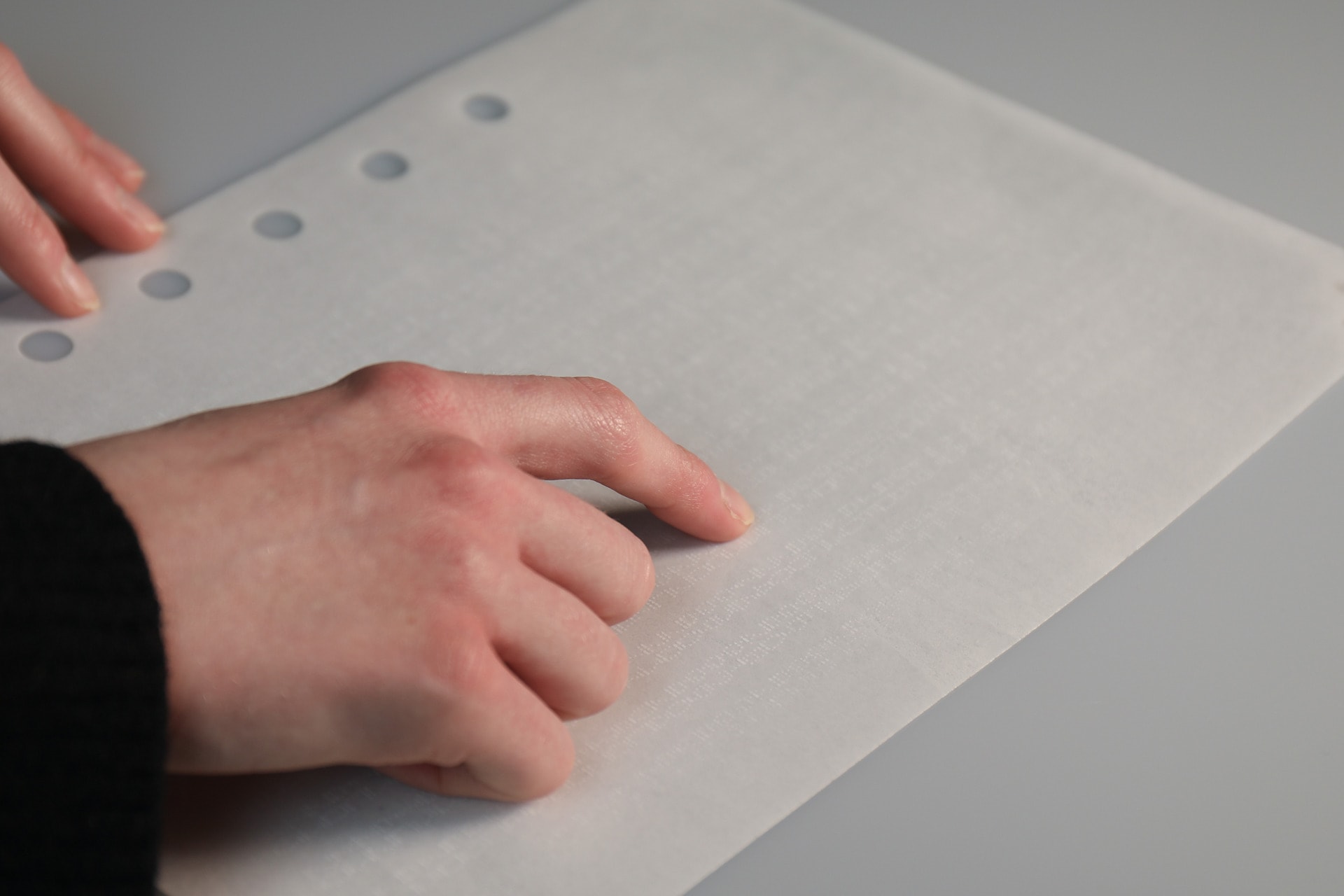 Photograph of right hand points to space code on edible booklet
