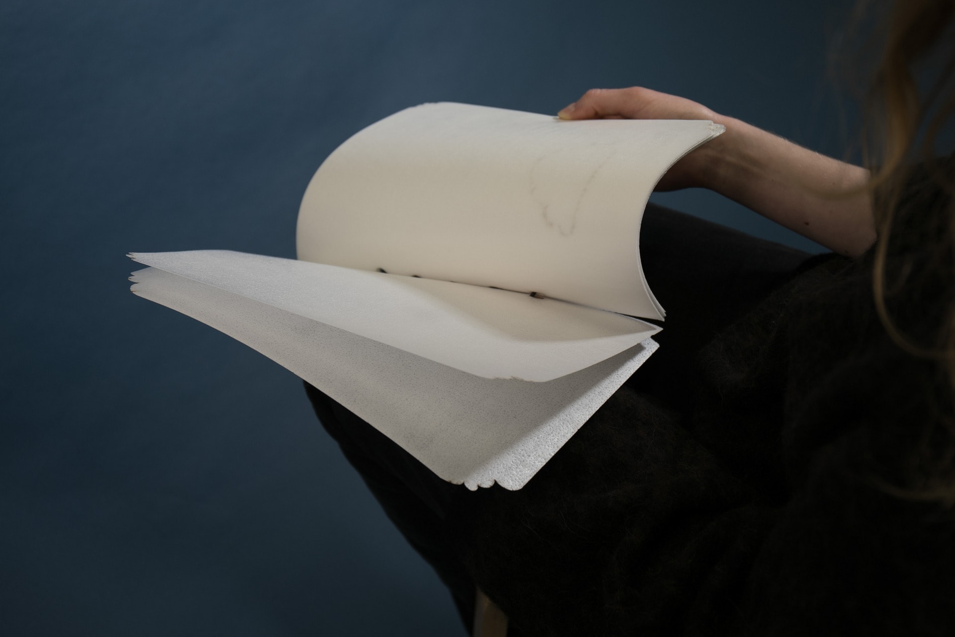 Hand holding delicate edible book, pages open