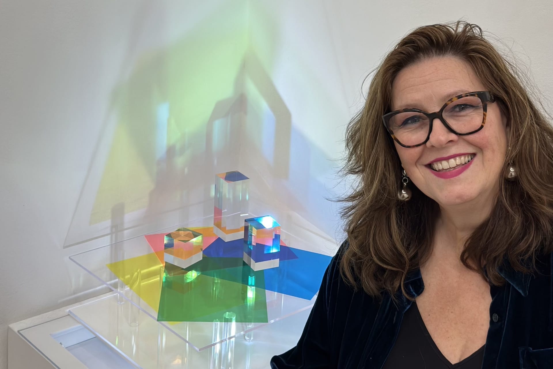 Szewska is standing by her multi coloured light and sculpture installation made of clear block acrylic and coloured acetate.