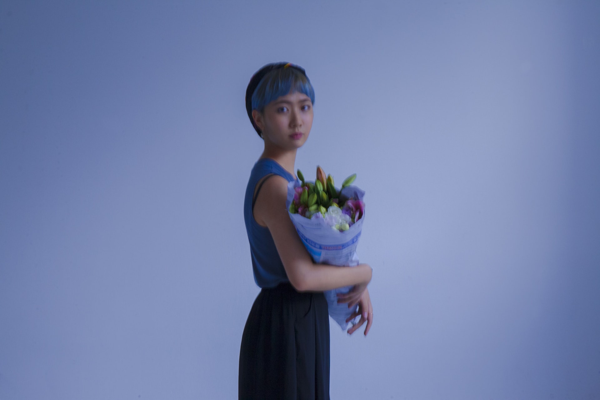 Photo of Nandal with a bouquet of flowers, staring at the camera.