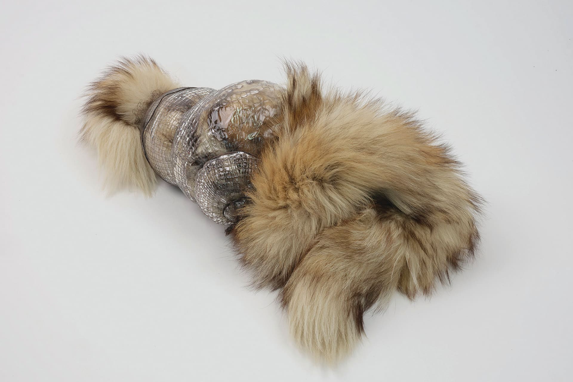 fur escapes from a horizontal glass vessel that is bound in copper mesh