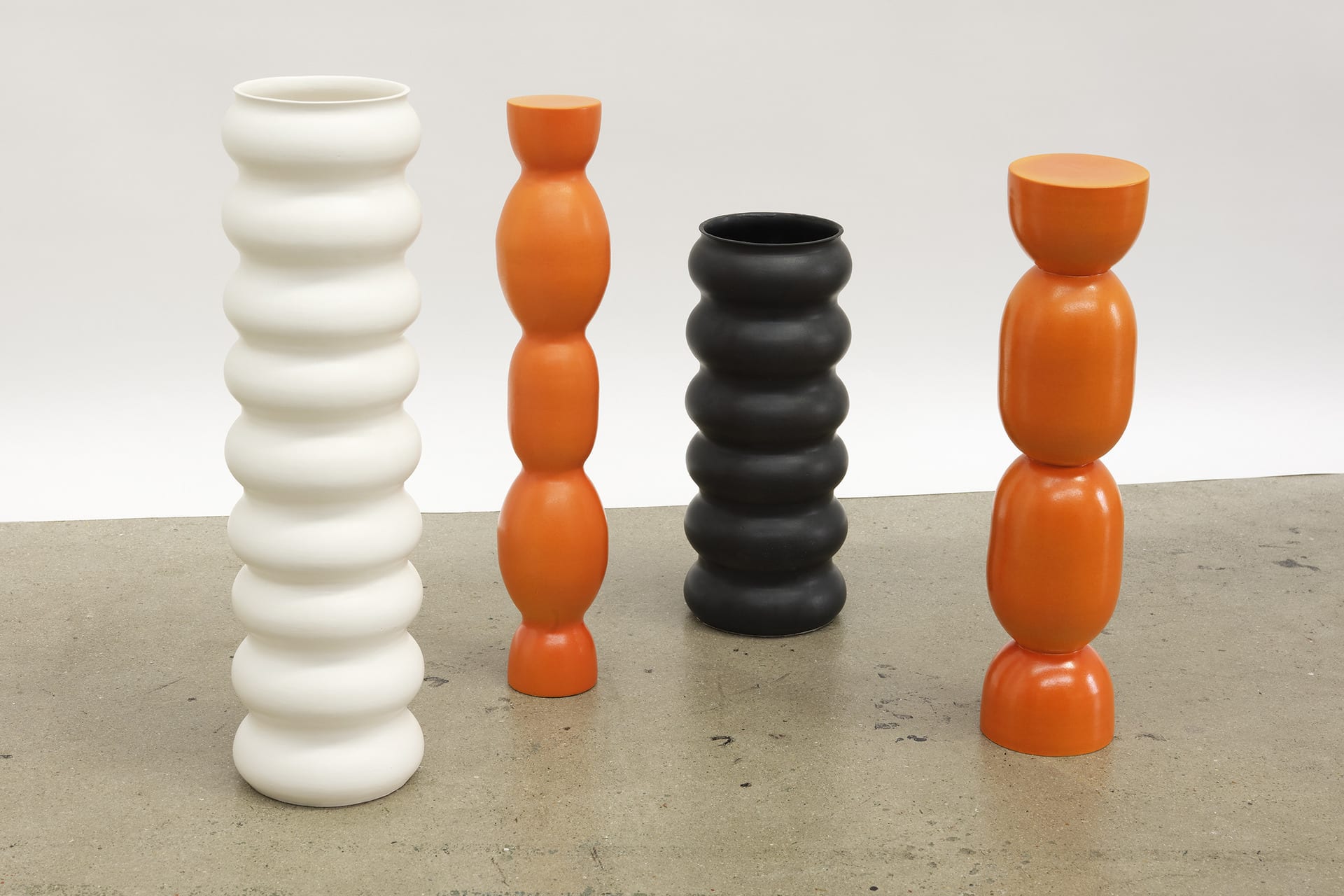 Wobbly tall vessels of slightly different shapes. Smooth appearance and a shiny surface