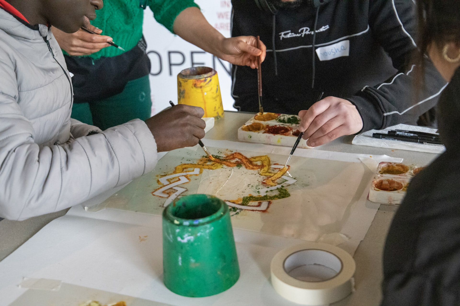 Workshop participants with Saima Rasheed painting with spices