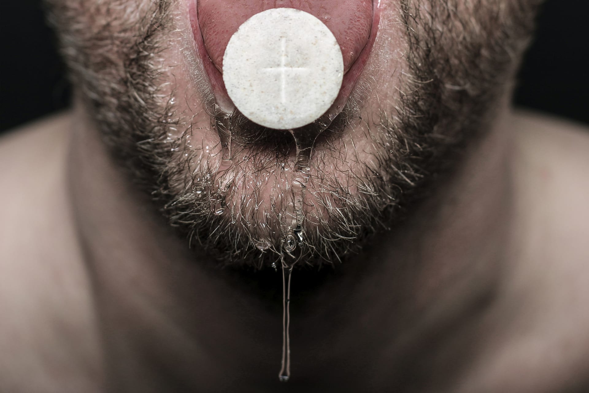 Close up of communion bread on a dribbling tongue