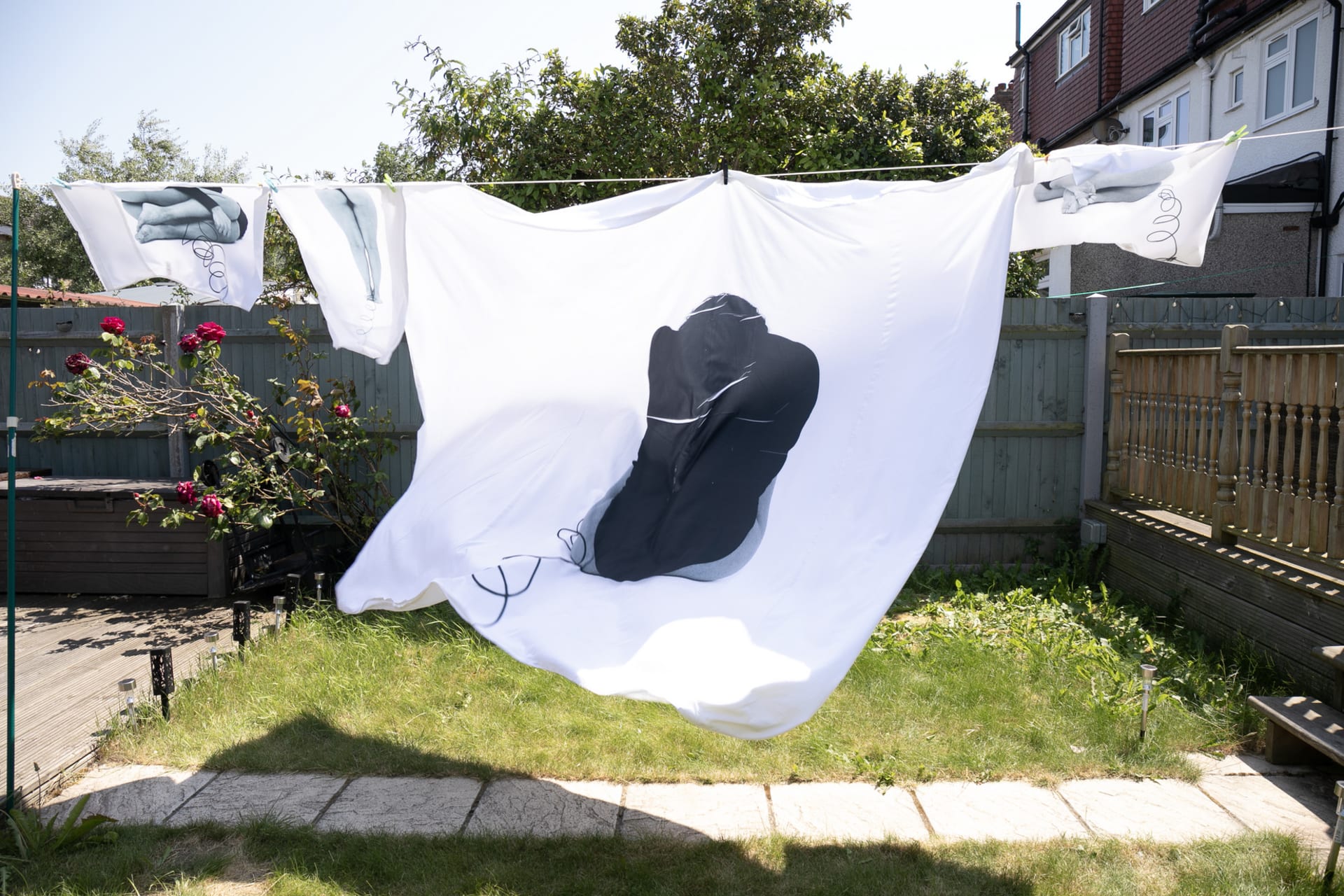 black and white self-portraits printed on a duvet cover and pillowcases, hanging on a washing line